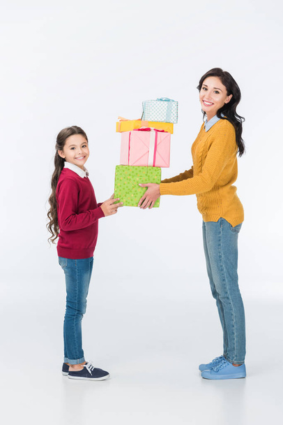 smiling mother and daughter with wrapped presents isolated on white  - Fotoğraf, Görsel