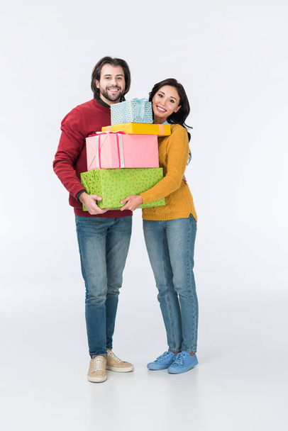 χαμογελώντας ζευγάρι με τυλιγμένα δώρα βλέπουν φωτογραφική μηχανή που απομονώνονται σε λευκό  - Φωτογραφία, εικόνα