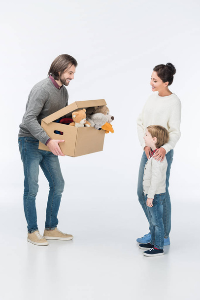 Feliz padre sosteniendo caja de cartón con juguetes aislados en blanco
  - Foto, imagen