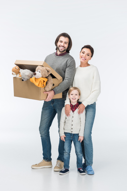 smiling father holding cardboard box with toys and looking at camera isolated on white  - Photo, Image