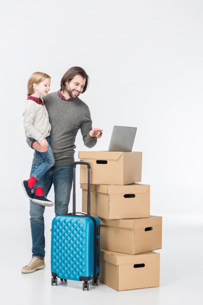 happy father with son using laptop on cardboard boxes isolated on white - Фото, зображення