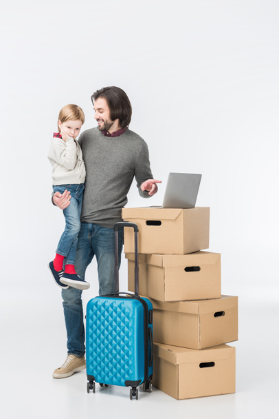 father with son using laptop on cardboard boxes isolated on white - Фото, зображення