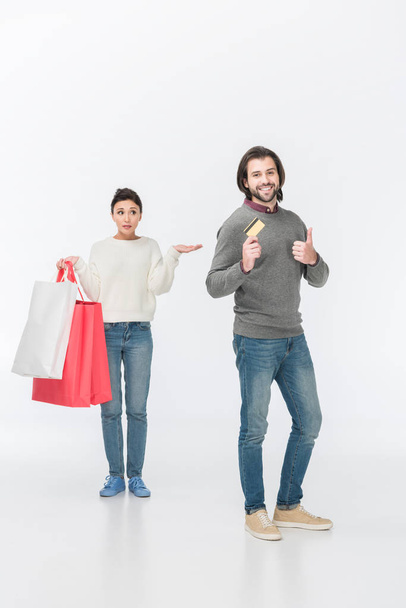 жінка з сумками для покупок, коли чоловік показує великий палець вгору і кредитну картку ізольовано на білому
  - Фото, зображення