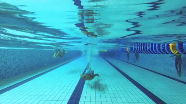 Teenager plave v bazénu pod vodou. - Záběry, video