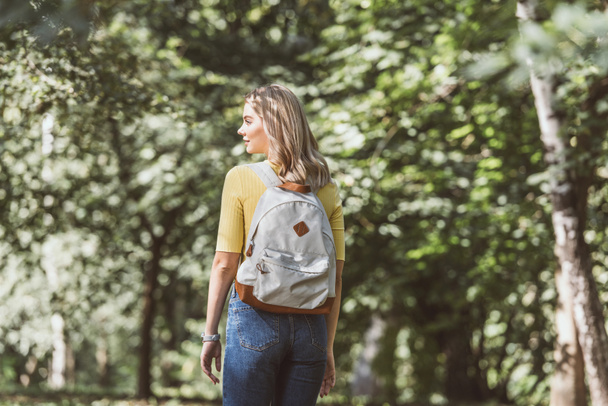 Powrót widzenia młoda blond kobieta z plecakiem w lesie - Zdjęcie, obraz