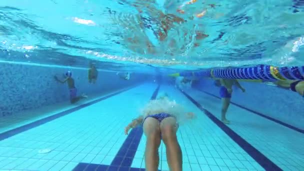 De tiener zwemt in het zwembad onder water. - Video