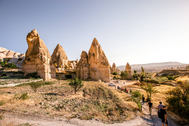 Fairy tale chimneys in Cappadocia on the background of blue sky in Turkey.The great tourist attraction of Cappadocia one of the best places to fly with hot air balloons. Goreme, Cappadocia, Turkey - Photo, image