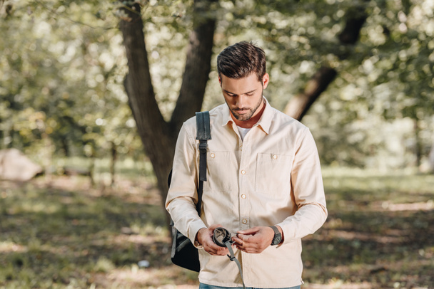 Porträt eines jungen Touristen mit Karte und Rucksack im Park - Foto, Bild
