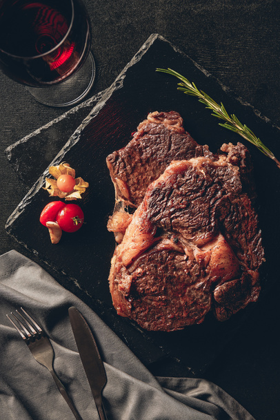 felülnézete a vágódeszkák, pohár vörös bor asztallapra konyhában főzött steak - Fotó, kép