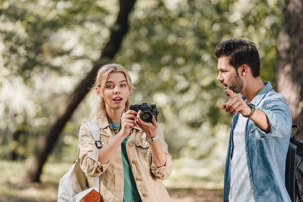 portrait of couple of young travelers with photo camera in park - Фото, зображення
