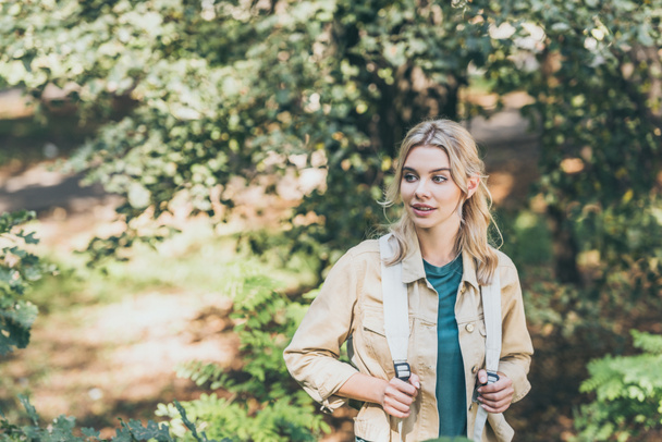 Porträt einer jungen nachdenklichen Touristin mit Rucksack im Park - Foto, Bild