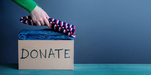 Donatie Concept. Marktlieden haar gebruikt oude kleren in een doos doneren - Foto, afbeelding