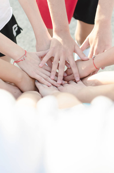 Crossed hands of young female handball team, teamwork greeting. Space for text. - Foto, Imagem