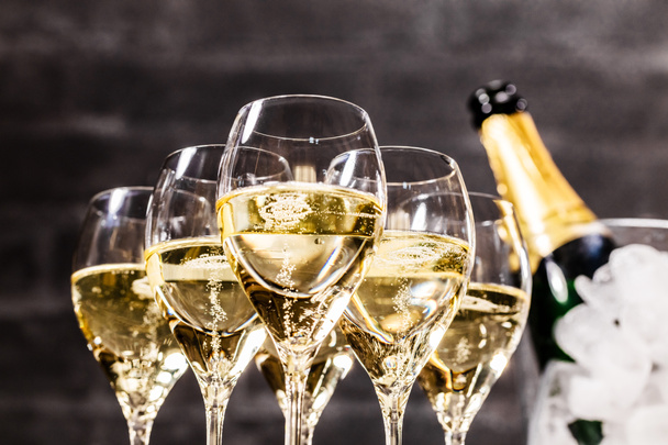 Champagnefles en bril op donkere achtergrond, close-up - Foto, afbeelding