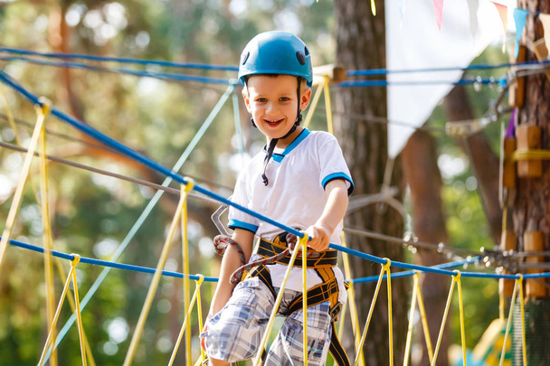 El chico sube a un parque de cuerdas
 - Foto, imagen