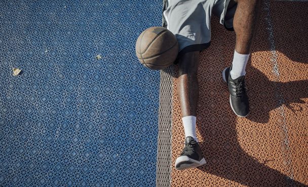 Unrecognisable African basketball player sitting on court. - Fotó, kép