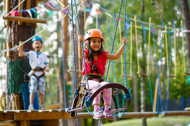 Хлопчик і дівчинка Тоддлер скелелазіння на мотузках обладнання на дитячому майданчику влітку
 - Фото, зображення