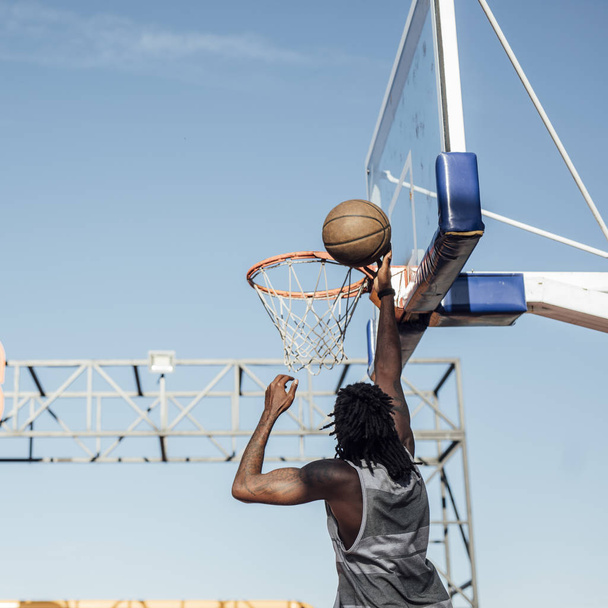 Young African man playing basketball on outdoor court. - Photo, Image