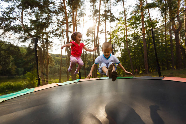 bahçede bir trambolin üzerinde küçük çocuklar - Fotoğraf, Görsel
