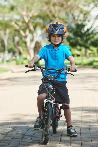 Wesoły chłopak zadowolony, jazda na rowerze w kasku - Zdjęcie, obraz