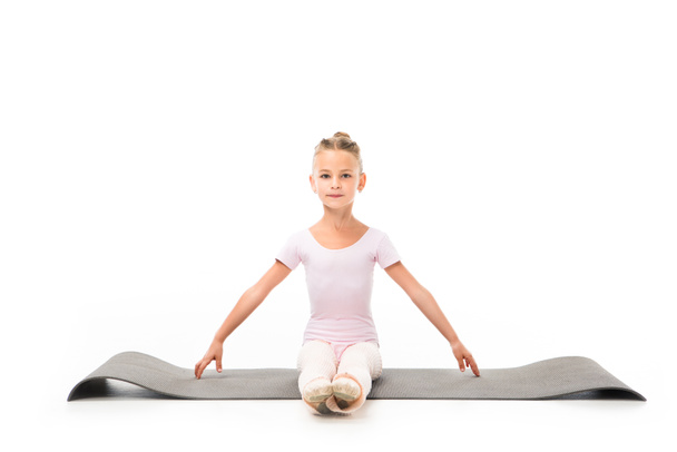 child practicing gymnastics exercises on fitness mat isolated on white background  - Photo, Image