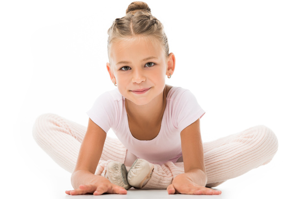 adorable little ballerina stretching and looking at camera isolated on white background  - Fotografie, Obrázek