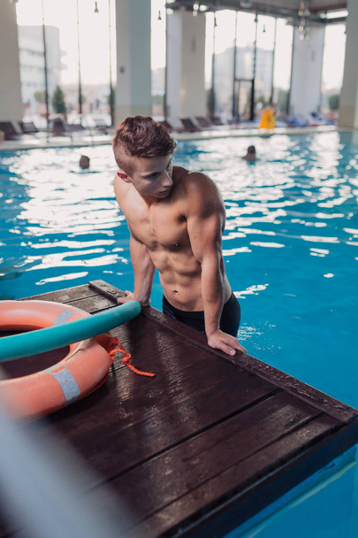 junger und fitter Mann am Pool - Foto, Bild