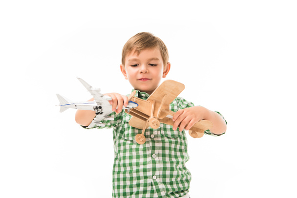 очаровательный маленький мальчик играет с игрушечными самолетами изолированы на белом фоне
 - Фото, изображение
