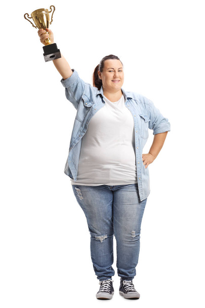 Full length portrait of an overweight woman holding a gold trophy cup isolated on white background - Foto, imagen
