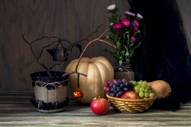 ハロウィンのコンセプトです。カボチャ、リンゴと木製の背景のクローズ アップの葡萄のある静物. - 写真・画像