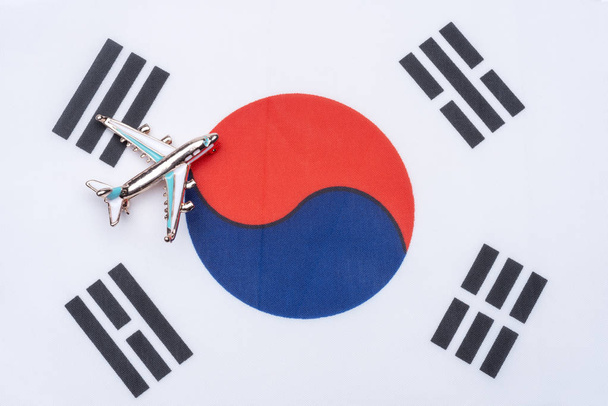 Σημαία της Νότιας Κορέας και το αεροπλάνο. Η έννοια του ταξιδιού. Αεροπλάνο παιχνίδι στη σημαία, Νότια Κορέα. - Φωτογραφία, εικόνα