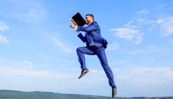 Boost speed online. Businessman laptop satisfied quality. Man with laptop jump or fly in air blue sky background. Excellent internet provider raise up quality connection. Internet connection so fast - Photo, Image