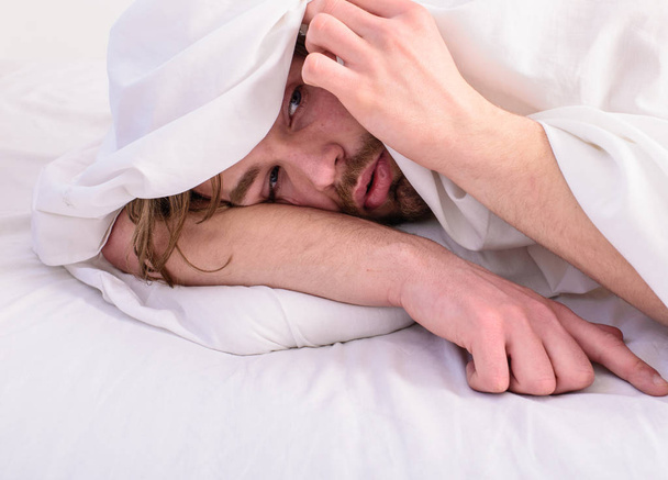 Man unshaven handsome relaxing bed. Let your body feel comfortable. Man sleepy drowsy unshaven bearded face covered with blanket having rest. Guy lay under white bedclothes. Fresh bedclothes concept - Foto, immagini