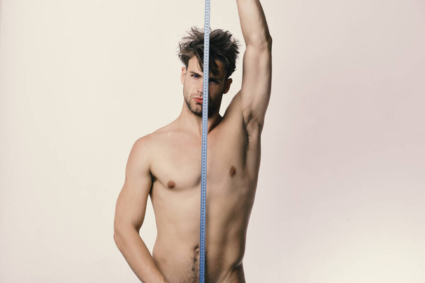 Man holds long blue measuring tape vertically - Foto, Imagen