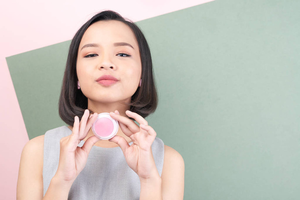Όμορφη βιετναμέζικα γυναίκα δείχνει lip balm που χρησιμοποίησε - Φωτογραφία, εικόνα
