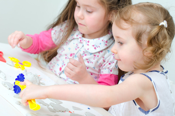 dvě malé holčičky vyřezávání pomocí hlíny - Fotografie, Obrázek