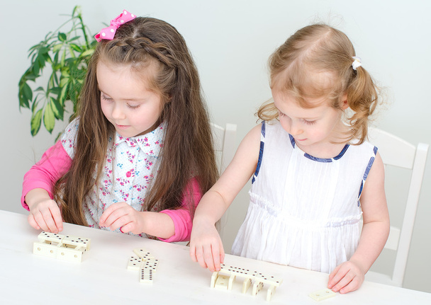 Duas meninas jogando dominó na mesa
 - Foto, Imagem