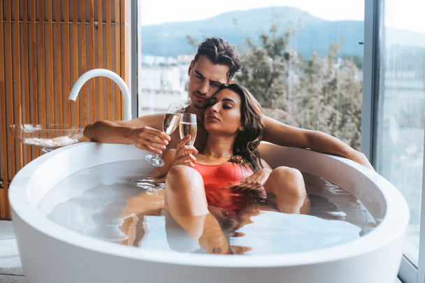 Beau couple bénéficiant d'un bain relaxant avec champagne
 - Photo, image