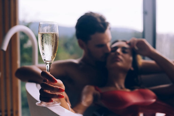 Bella coppia godendo di un bagno rilassante con champagne
 - Foto, immagini