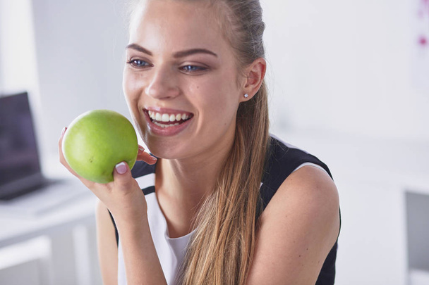 Молода красива усміхнена дівчина з зеленим яблуком в руках
 - Фото, зображення