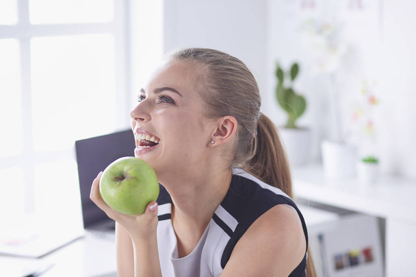 Young beautiful smiling girl with a green apple in hands - Photo, Image
