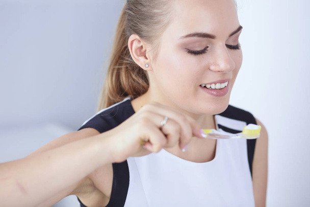 Smiling young woman with healthy teeth brushing her teeth - Foto, immagini