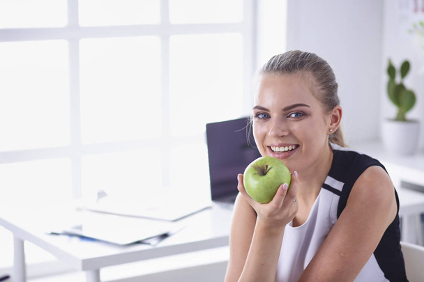 Young beautiful smiling girl with a green apple in hands - Foto, afbeelding