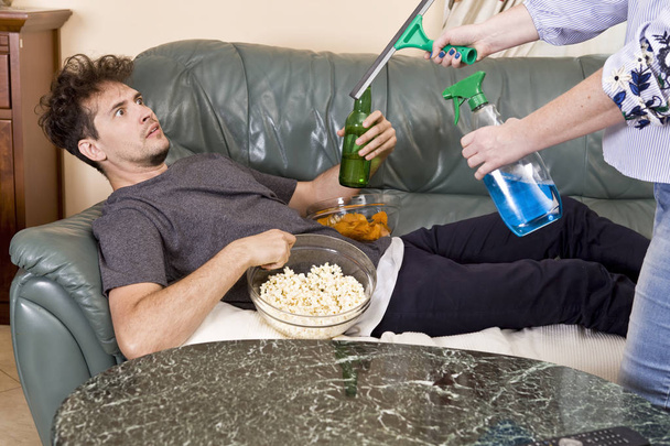Man with beer and chips watching TV at home. Wife and husband relationship - Photo, image