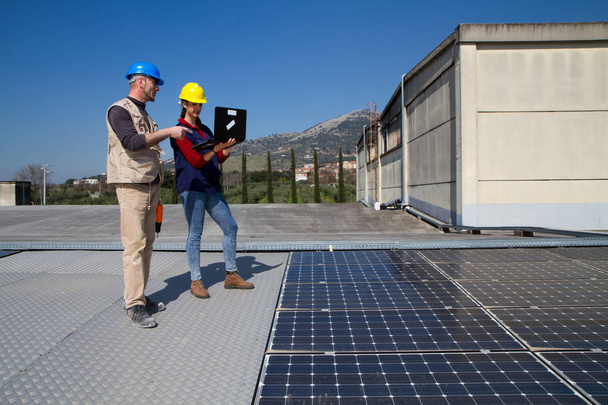 joven ingeniera y un trabajador calificado de edad avanzada instalando una planta fotovoltaica
 - Foto, Imagen
