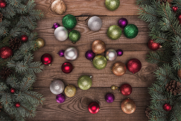 ylhäältä näkymä kiiltävä värikäs helyjä ja joulukuusi oksat puinen tausta
 - Valokuva, kuva
