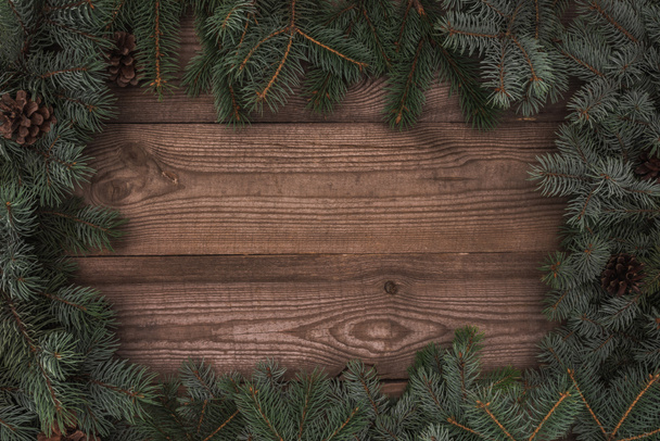 bellissimi rami di conifere sempreverdi e pigne su sfondo di legno
   - Foto, immagini