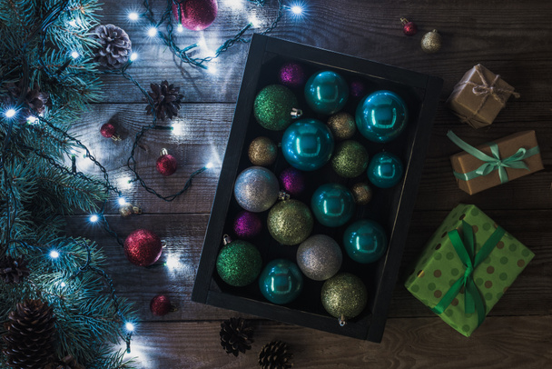 vue de dessus des cadeaux de Noël, des boules brillantes et des brindilles de sapin avec guirlande illuminée sur fond en bois
  - Photo, image
