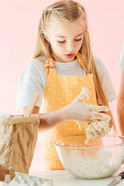 adorable teen child kneading dough isolated on pink - Foto, Imagen