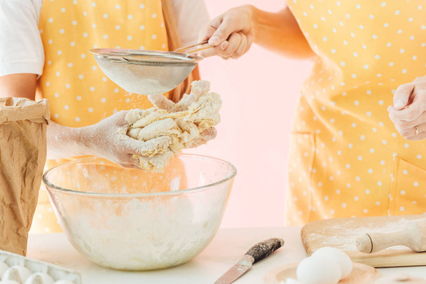 cropped shot of mother and daughter preparing dough together isolated on pink - Fotoğraf, Görsel